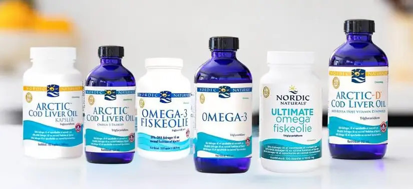 Her ses seks Nordic Naturals produkter i skiftevis blå og hvid. Baggrunden er lys, men slørret.