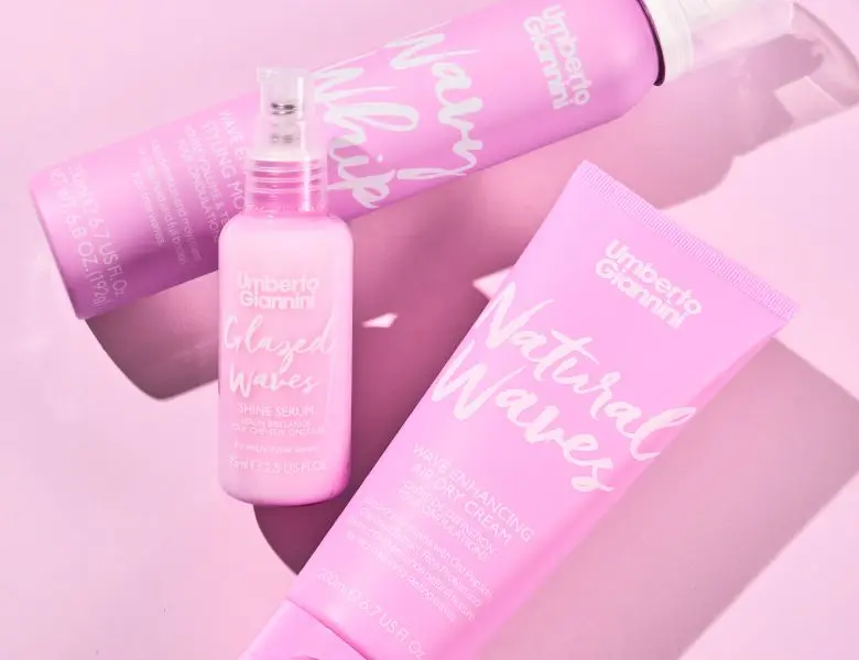 Tre lyserøde Umberto Giannini hårprodukter til at fremhæve bølger: Wavy Whip mousse, Glazed Waves serum og Natural Waves creme.