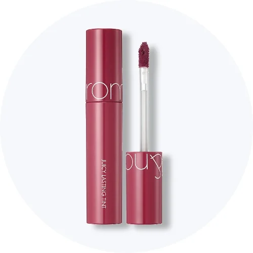 Her ses en rom&nd Juicy Lasting Tint i mørkerød emballage med applikatoren vist ved siden af på en lys baggrund.