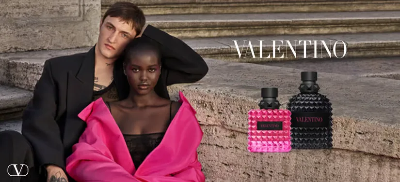 Her ses en kvinde i pink og en mand i sort. Til højre for dem ses en pink dameparfume og en sort mandeparfume samt et Valentino logo. 