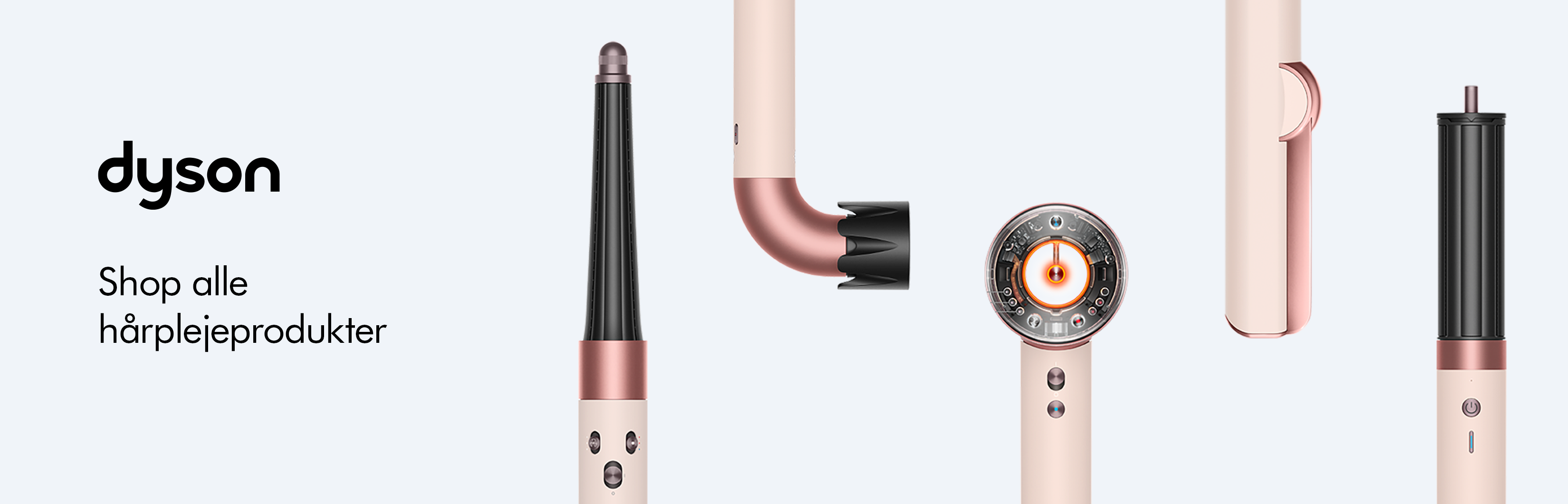 Her ses et kampagnebillede for Dyson Beauty med et udvalg af hårstylingprodukter og tilbehør i Ceramic Pink/Rose Gold. Produkterne vises enkeltvis fra forskellige vinkler mod en lys baggrund og omfatter blandt andet styling- og krølletilbehør samt en hårtørrer. I den brede version står Dyson-logoet til venstre sammen med teksten “Shop alle hårplejeprodukter”.
