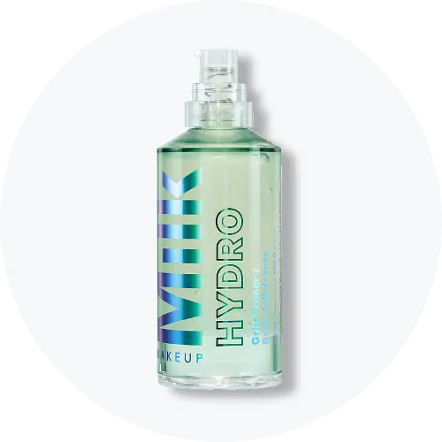 Her ses Milk Makeup Hydro Grip Primer i en transparent flaske med lysegrønt produkt og holografisk tekst. På emballagen står “Milk Makeup”, “Hydro” og “Grip Primer”.