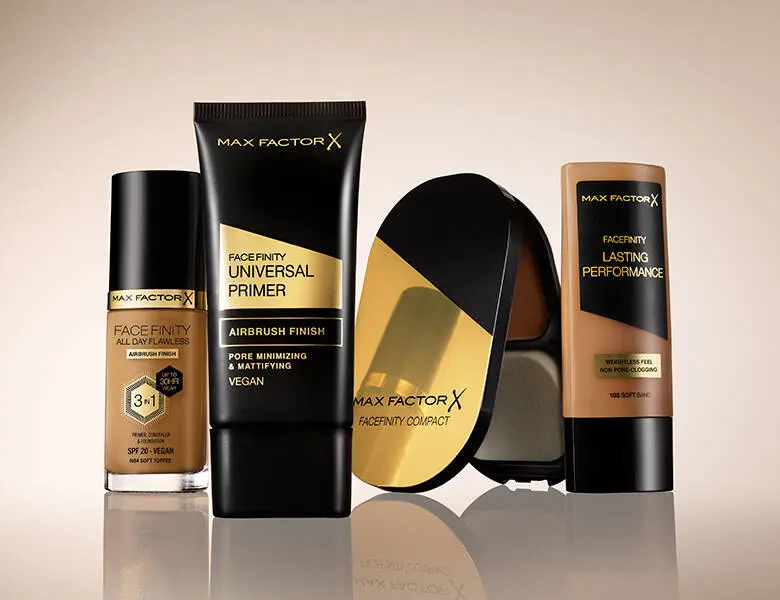 Her ses fire Max Factor makeup produkter på en række. Baggrunden er lysebrun.