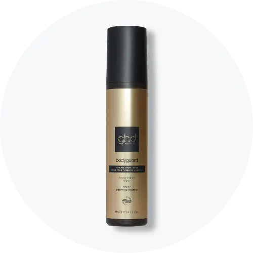 Her ses ghd Bodyguard Heat Protect Spray i en guldfarvet sprayflaske med sort låg. På emballagen står blandt andet “ghd”, “Bodyguard” og “Heat Protect Spray”.