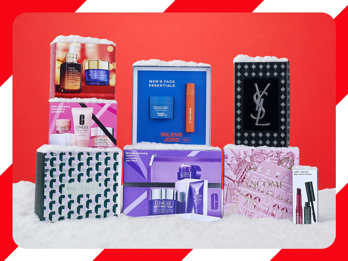 Festlige skønhedsgavesæt fra Estée Lauder, Clinique, YSL og Lancôme, præsenteret med kunstig sne.