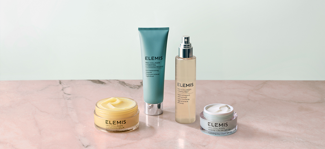 Her ses ELEMIS hudplejeprodukter – ansigtsrens, cleansing balm, mist og ansigtscreme på en marmorbordplade foran en lys baggrund.