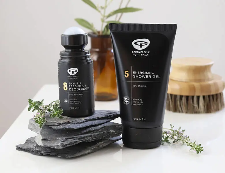 Her ses to sorte Green People produkter, hvoraf det ene står på nogle sorte sten. 