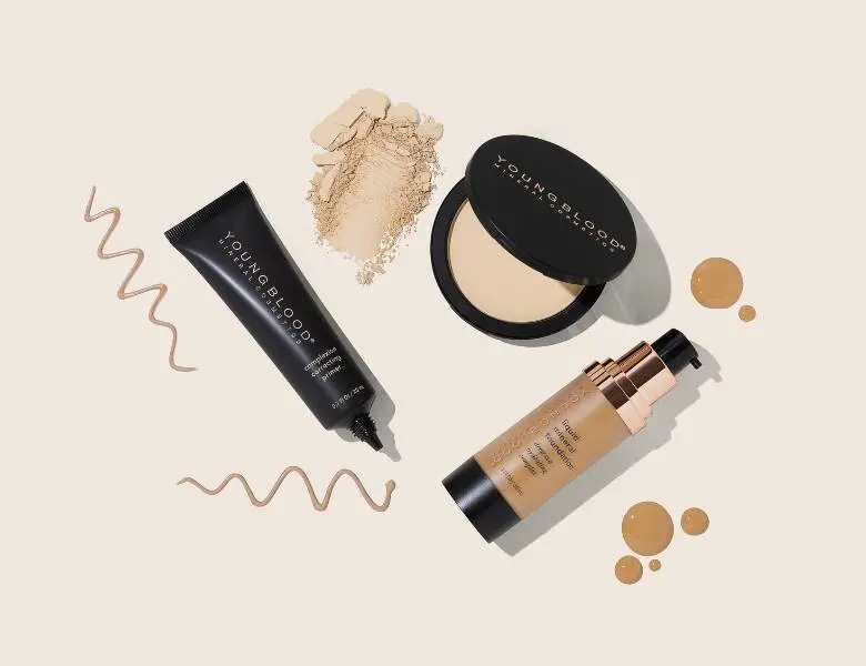 Herses en lys baggrund med forskellige makeupprodukter til ansigtet.