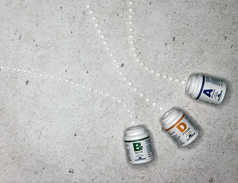 Her ses en grå baggrund med tre forskellige pilleglas. Der ligger piller ud fra hvert glas.