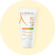 Her ses en solcreme fra A-Derma med faktor 50 og uden parfume. Den står på en lysegul baggrund.