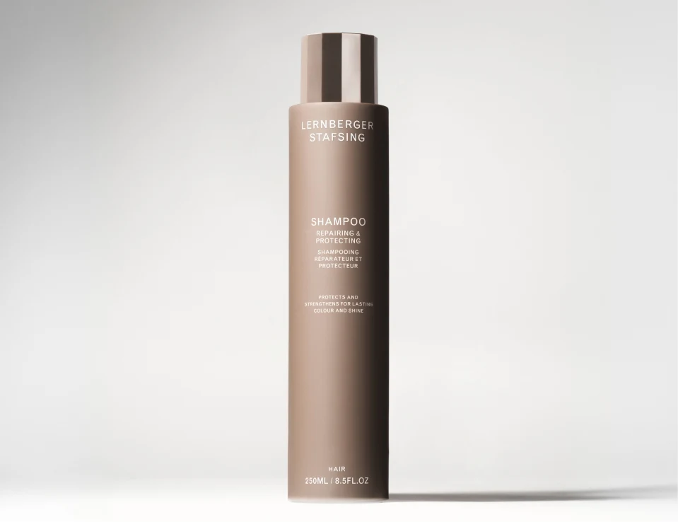 Her ses Lernberger Stafsing Shampoo Repairing & Protecting i en brun flaske mod en lys baggrund.