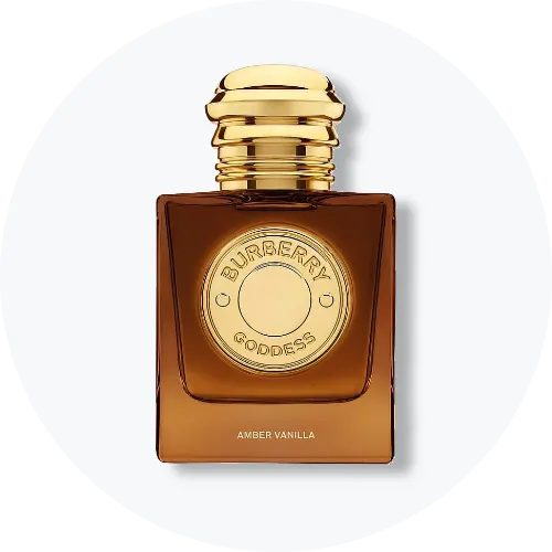 Her ses Burberry Goddess Amber Vanilla i en ravfarvet, firkantet parfumeflakon med guldfarvet låg. På forsiden ses det runde Burberry Goddess-emblem, og nederst står teksten “Amber Vanilla”. Flakonen står centralt mod en lys, rund baggrund.