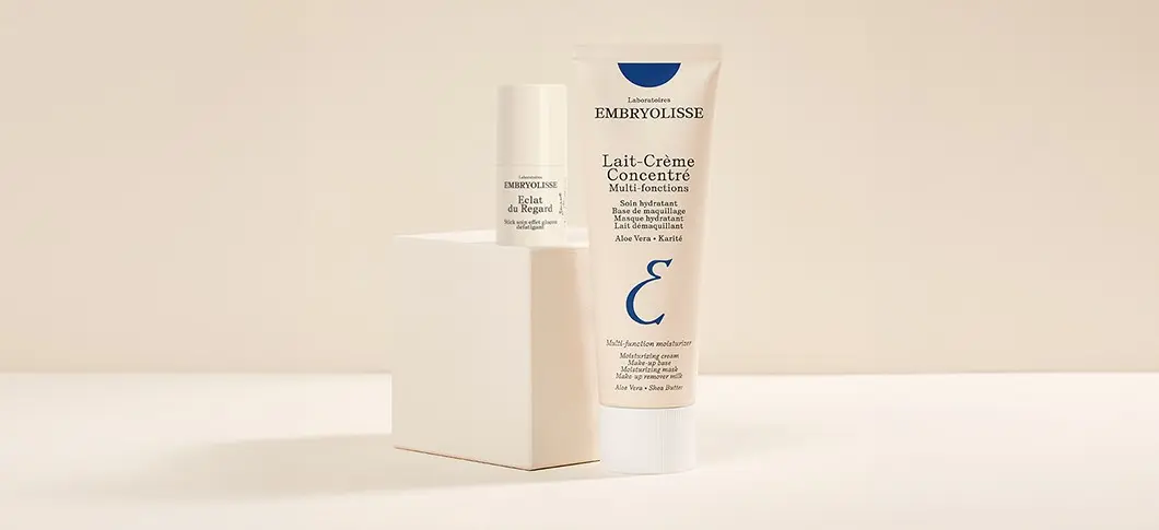 Embryolisse Lait-Crème Concentré multi-funktionel fugtighedscreme og Eclat du Regard øjenstick på en hvid blok.