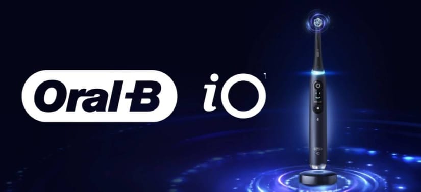 Oral-B iO eltandbørste står oprejst i oplader på mørk blå baggrund med lysende effekter, ved siden af Oral-B iO-logo.