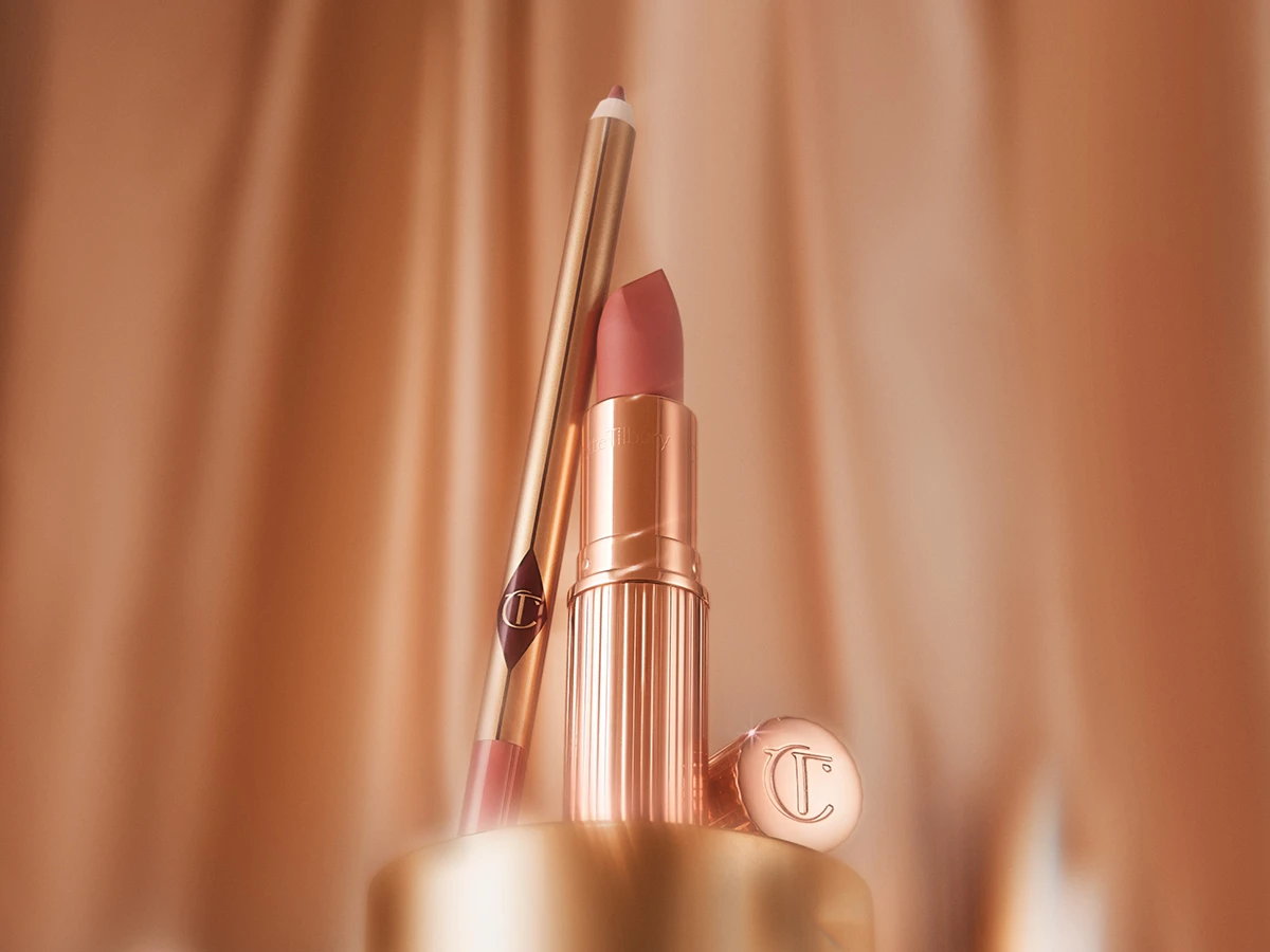 En åben rose guld læbestift med lyserød farve og en matchende læbepencil, begge med Charlotte Tilbury branding.