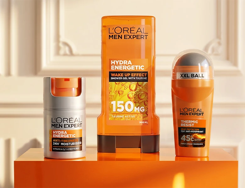 Her ses tre L’Oréal Men Expert-produkter fra Hydra Energetic-serien på en orange sokkel: ansigtscreme, shower gel og antiperspirant.