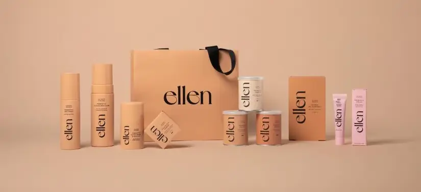 Her ses en Ellen pose med Ellen produkter omkring sig i varme nuancer. Baggrunden er en mørkere varm beige.