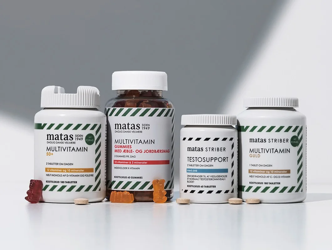 Fire Matas Striber multivitaminprodukter står på lys baggrund med vingummier og tabletter foran 