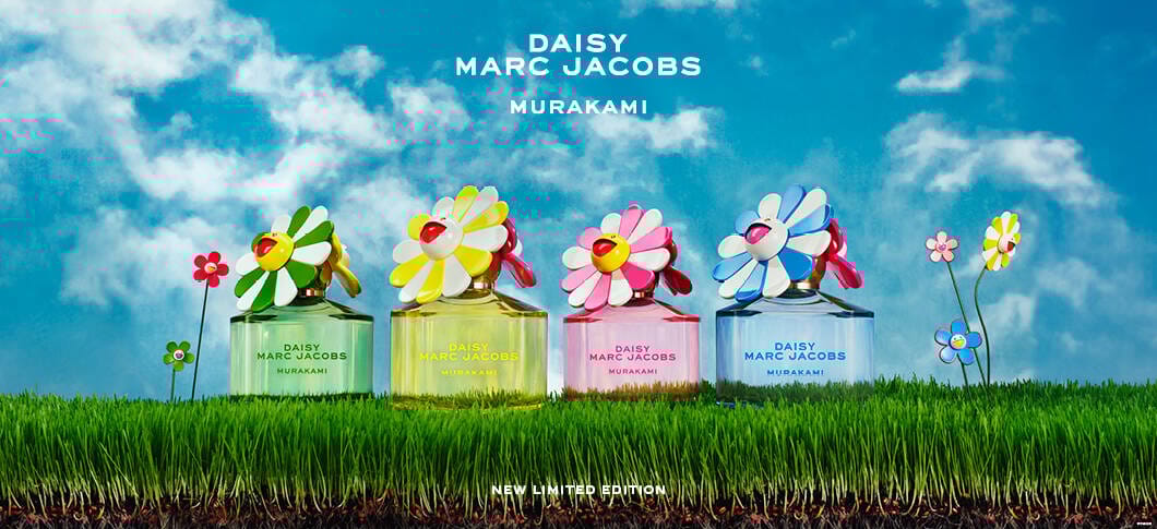 Her ses fire marc jacobs parfumer i forskellige farver, grøn, gul, lyserød og blå, stående på grønt græs og med en blå himmel bag.