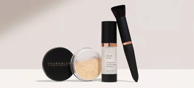 Her ses en lys baggrund med forskellige Youngblood makeupprodukter. 