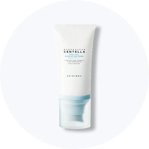 Her ses en SKIN1004 Madagascar Centella Hyalu-Cica Water-Fit Sun Serum SPF 50+ i hvid emballage med lyseblå detaljer på en lys baggrund.