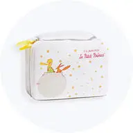 Hvid Clarins toilettaske med motiv fra Le Petit Prince og små gyldne stjerner på lys grå baggrund.