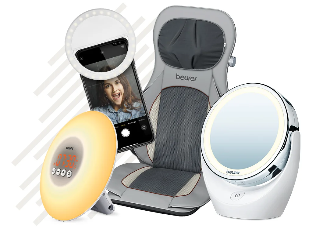 Udvalg af wellness-elektronik med lysterapilampe, mobil med ring light, Beurer massagesæde og rundt makeup-spejl med lys.