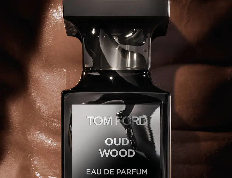 Her ses en mørkebrun baggrund med en sort Tom Ford parfume.