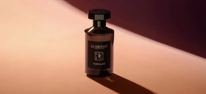 Her ses en Le Couvent parfume på en rødlig baggrund.
