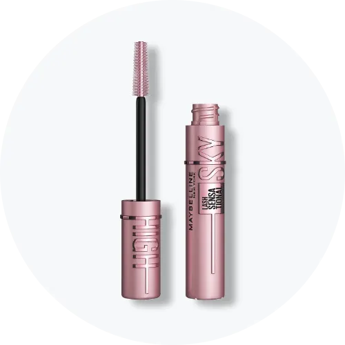 Her ses et billede af en mascara fra Maybelline placeret centralt mod en lys, rund baggrund. Produktet vises både åbent og lukket med synlig børste, og på emballagen står teksten “LASH SENSATIONAL SKY HIGH”.