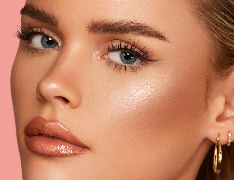 Her ses et close-up billede af en kvinde. Hun har makeup på, men hendes skinnende læber er i fokus. 