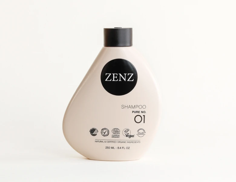 Her ses en ZENZ shampoo i en lys flaske med sort låg på en lys baggrund.