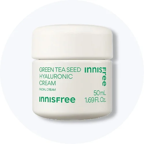 Her ses en Innisfree Green Tea Seed Hyaluronic Cream i en hvid krukke med grøn tekst på en lys baggrund.