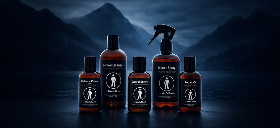 Her ses hudplejeprodukter fra By Men’s Room – cleanser, serum, creme og olie i mørke flasker foran en mørk baggrund med bjerge og vand.