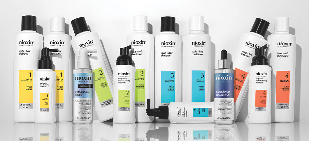 Her ses en række Nioxin produkter på en lyseblå baggrund.