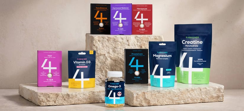 Her ses forskellige vitaminer og kosttilskud fra 4 HIM & HER placeret i forskellig højde på tre lyse flisesten foran en beige baggrund.