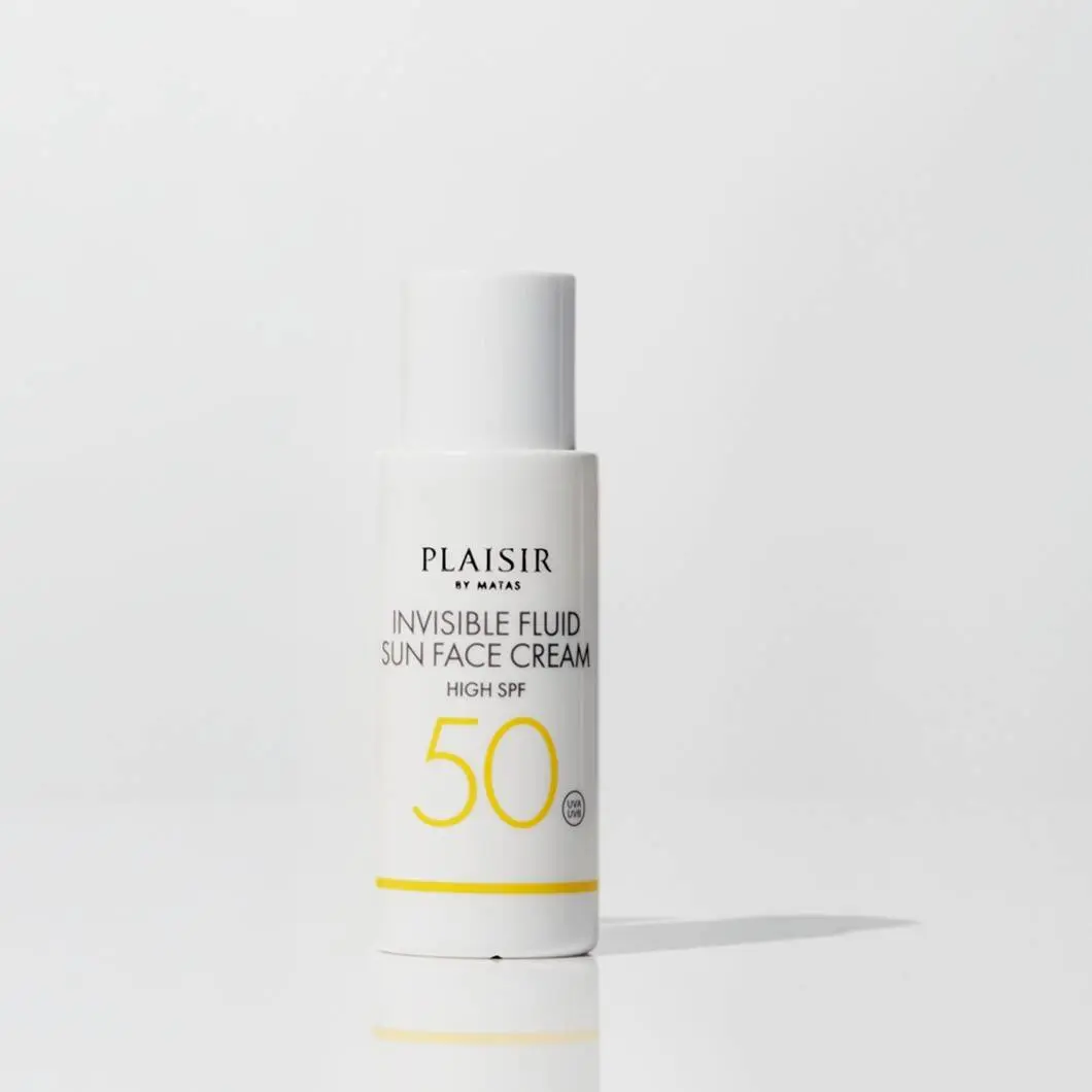 En hvid flaske med ansigtssolcremen ‘Invisible Fluid Sun Face Cream’ fra Plaisir by Matas står på en lys baggrund. Produktet har solfaktor 50 markeret med store gule tal på forsiden. Designet er enkelt og minimalistisk med fokus på solbeskyttelse til ansigtet.