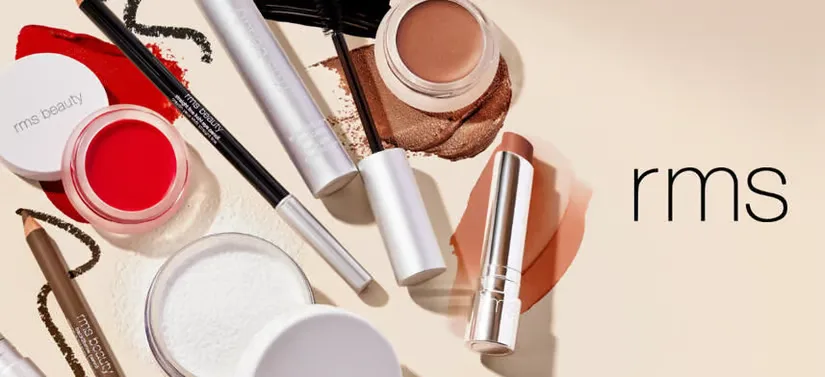 Her ses en beige baggrund med en masse RMS makeup produkter i venstre side. Til højre ses deres logo.