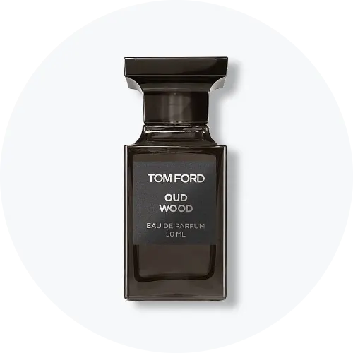 Her ses Tom Ford Oud Wood Eau de Parfum i en mørk, rektangulær parfumeflakon med et bredt sort låg. På forsiden står “Tom Ford Oud Wood – Eau de Parfum 50 ml”. Flakonen står centralt mod en lys, rund baggrund.