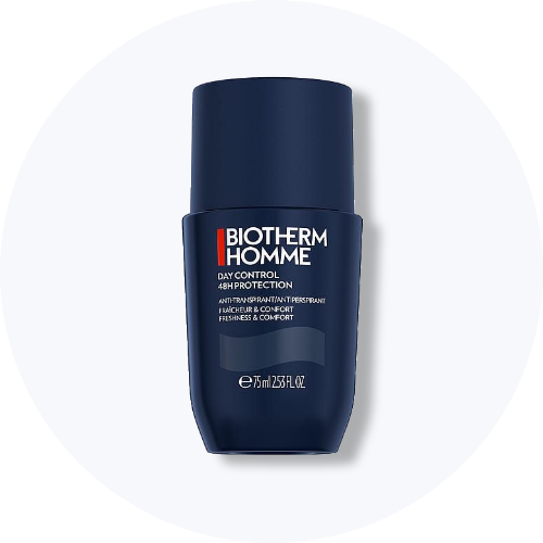 Her ses et billede af en deodorant fra Biotherm Homme placeret centralt mod en lys, rund baggrund. På produktet står teksten “BIOTHERM HOMME DAY CONTROL 48H PROTECTION”. Produktet er i mørkeblå emballage.