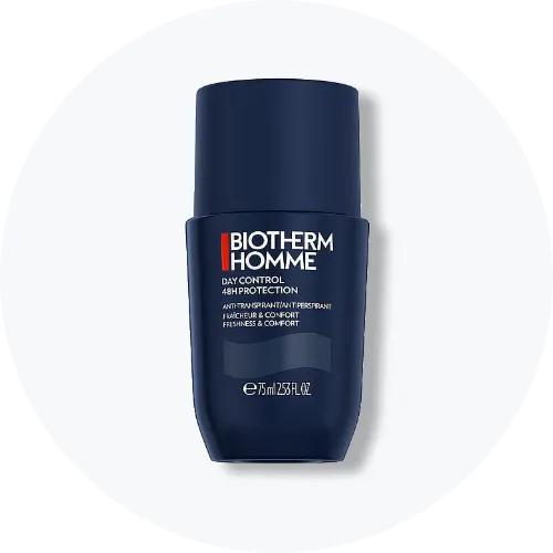 Her ses et billede af en deodorant fra Biotherm Homme placeret centralt mod en lys, rund baggrund. På produktet står teksten “BIOTHERM HOMME DAY CONTROL 48H PROTECTION”. Produktet er i mørkeblå emballage.