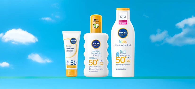 Her ses NIVEA SUN solprodukter i hvide flasker med SPF 50 på en blå baggrund med skyer.
