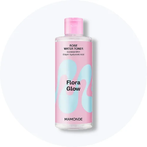 Her ses en Mamonde Flora Glow Rose Water Toner i en gennemsigtig flaske med pink og lyseblå etiket på en lys baggrund.