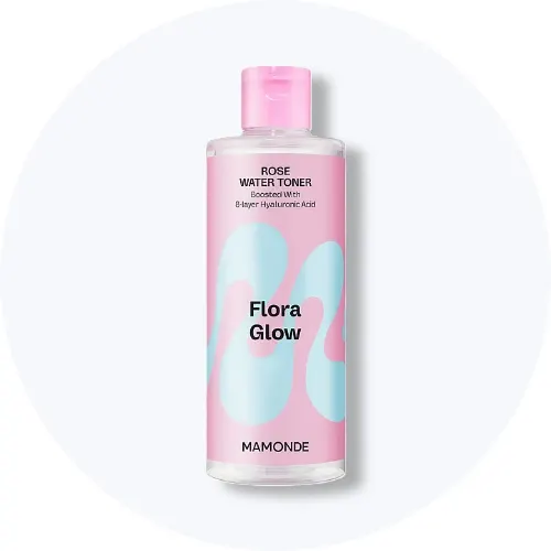 Her ses en Mamonde Flora Glow Rose Water Toner i en gennemsigtig flaske med pink og lyseblå etiket på en lys baggrund.