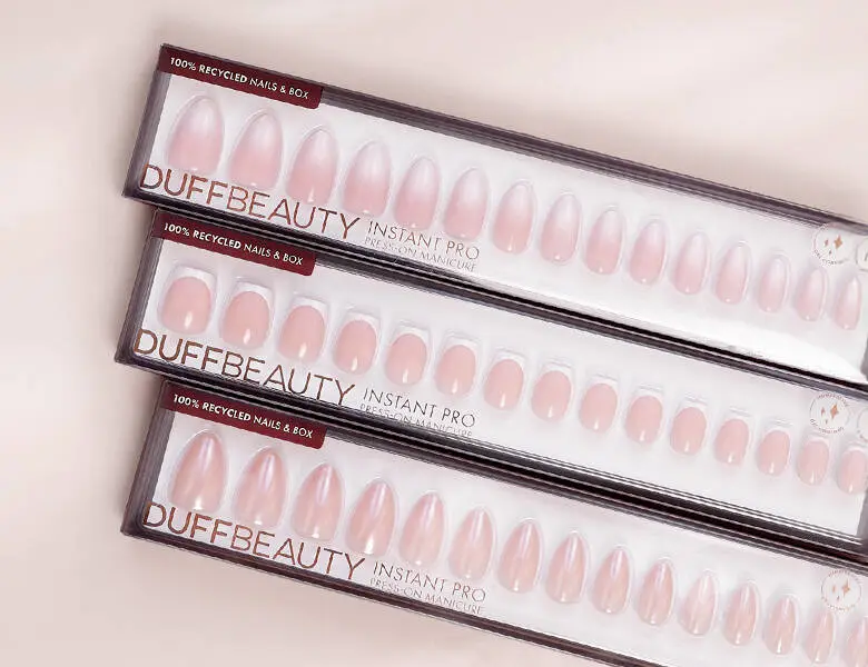 Her ses nogle forskellige lyserøde negle fra DUFFBEAUTY på en lys lyserød baggrund.