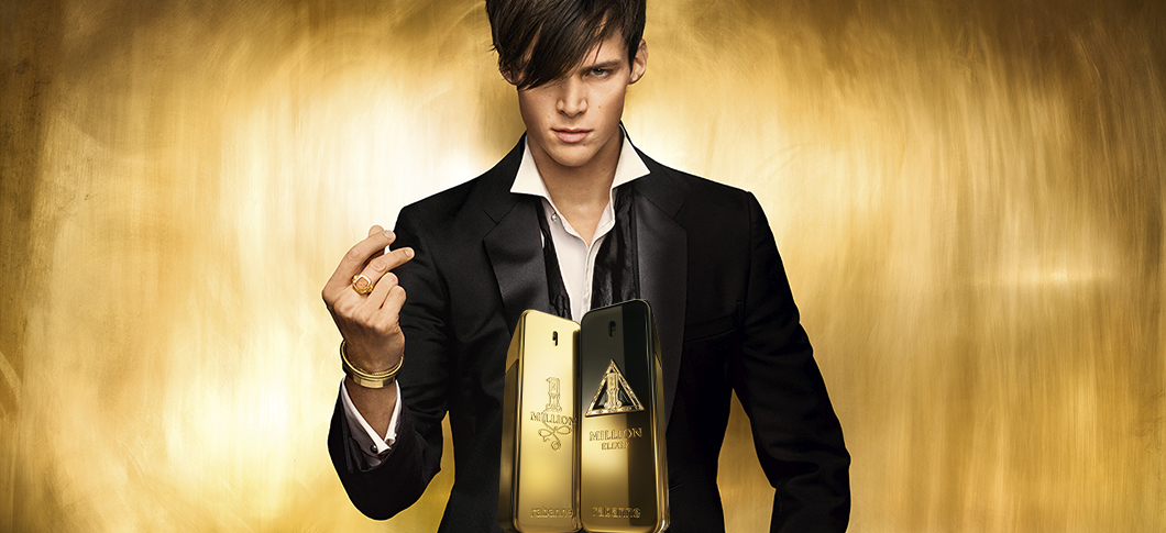 Her ses et billede med en person placeret centralt mod en gylden baggrund. Foran personen ses to parfumeflakoner i guldfarvede og sorte nuancer.