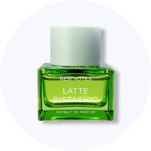 Her ses et billede af en parfumeflakon fra New Notes placeret centralt mod en lys, rund baggrund. På flakonen står teksten “LATTE PISTACHIO EXTRAT DE PARFUM”. Flakonen er i grøn nuance med lyst låg.