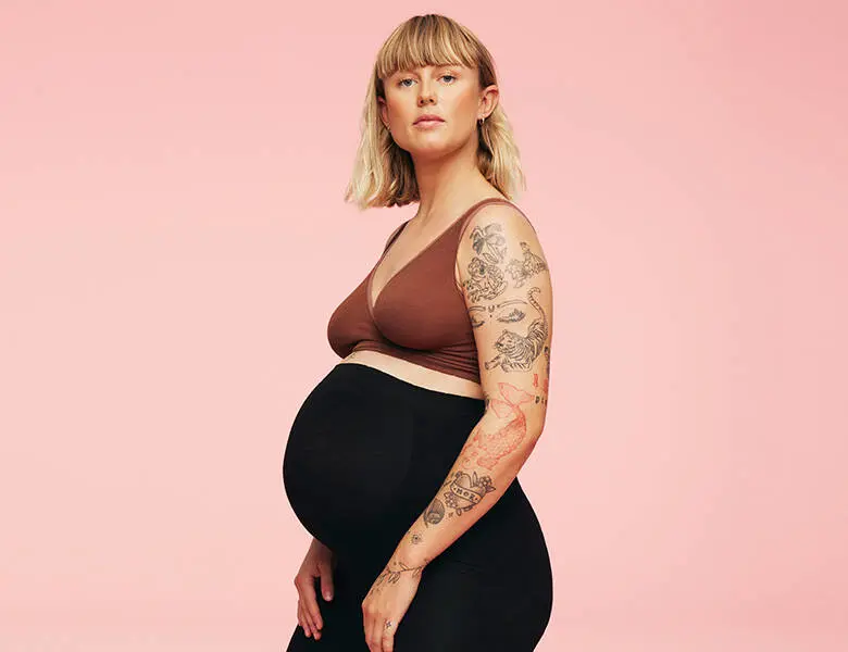 Her ses en lyserød baggrund med en gravid kvinde på.