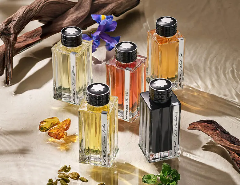 Her ses en masse forskellig farvede parfumer i noget klart vand med planter. 
