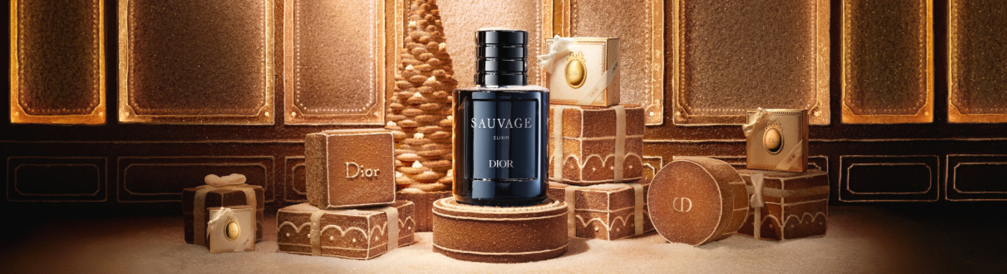 Dior Sauvage Elixir parfumeflaske omgivet af luksuriøse Dior gaveæsker med ingefærbrød-tekstur og et festligt træ.
